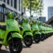 Rijen groene elektrische deelscooters opgeslagen op een industrieterrein in Nederland na faillissement