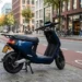 Elektrische scooter geparkeerd in stad als voorbeeld van overstap naar elektrisch rijden